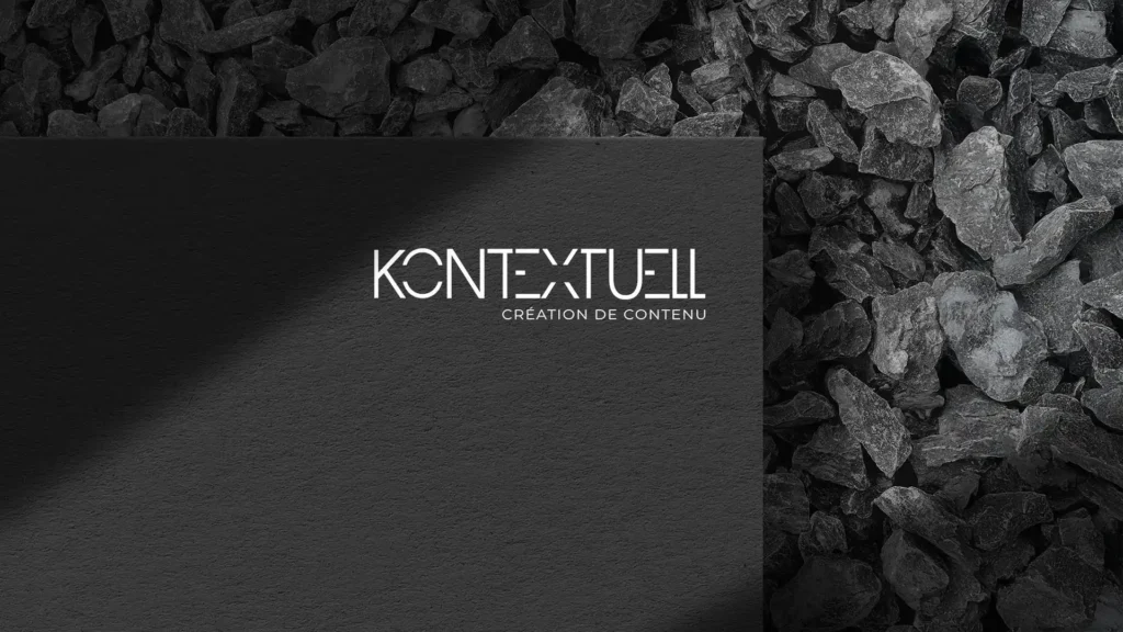 Carte noire avec le logo "KONTEXTUELL" et la mention "CRÉATION DE CONTENU" en blanc, sur un fond de pierres noires.