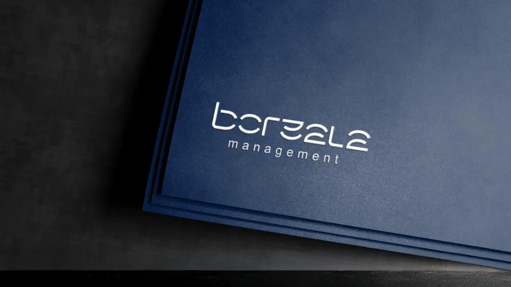 Un dossier bleu foncé avec le logo blanc "boreala management", en lettres cursives, posé sur une surface sombre avec un effet de profondeur.
