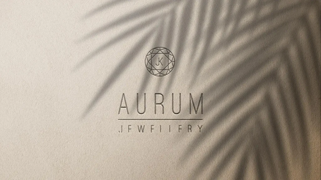 Maquette d'un logo "AURUM JEWELLERY" en lettres fines sur un fond texturé beige clair, avec un logo rond en filigrane et une ombre de feuille de palmier projetée sur le côté droit.