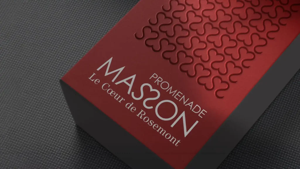 Boîte rouge avec le texte 'MASSON PROMENADE Le Coeur de Rosemont' et un motif répété de trèfles, sur un fond gris texturé.