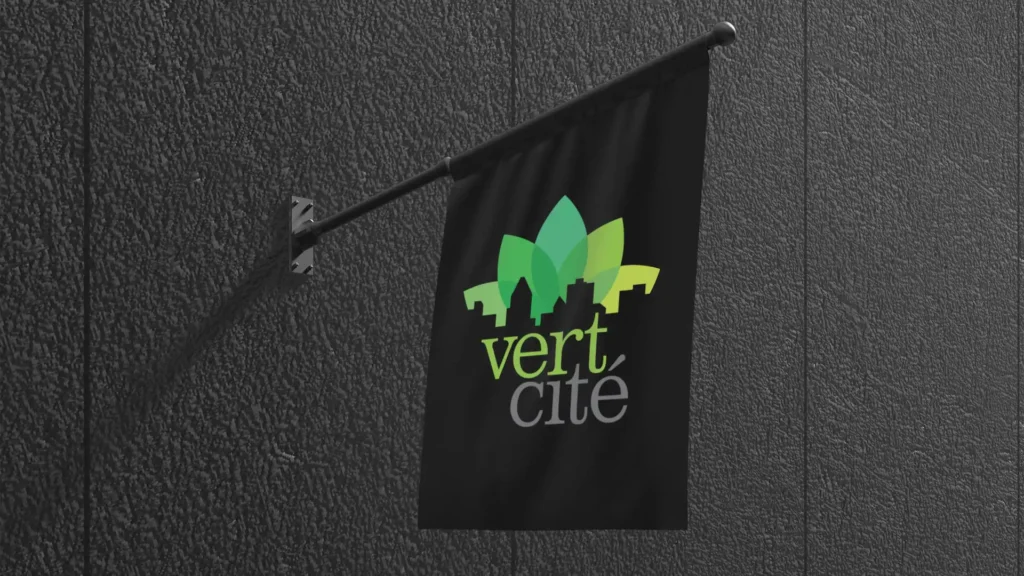 Un drapeau noir rectangulaire avec le logo vert et jaune "vert cité" représentant une ville stylisée, fixé à un mur texturé gris foncé.
